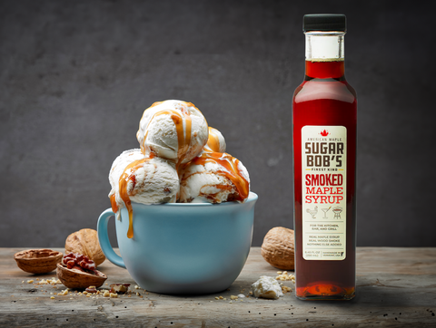 Bowl of vanilla ice cream topped with Sugar Bob’s smoked maple syrup, apple pie almonds, and maple sriracha cashews