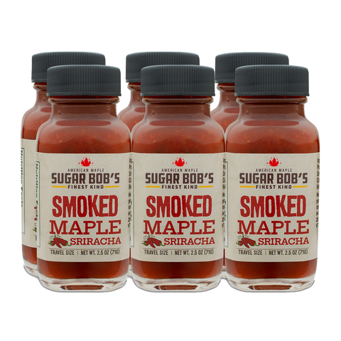 Six bottles of Smoked Maple Sriracha sauce on a white background.
