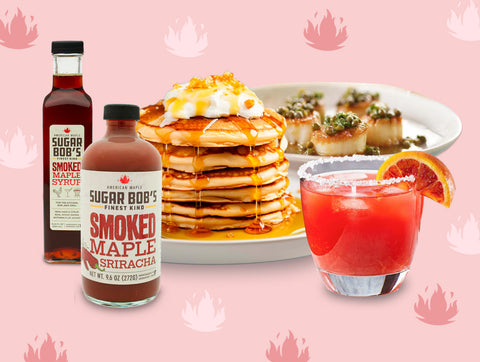 An artisanal kitchen pantry featuring Sugar Bob’s Smoked Maple Syrup, Maple Sriracha bottles, and spiced nuts on a rustic Vermont wood table.