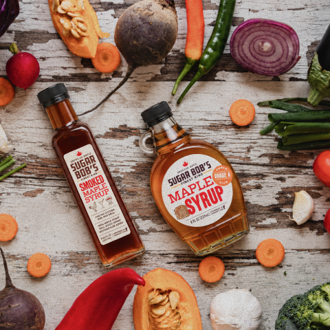 Sugar Bob's Smoked Maple Syrup and Pure Vermont Maple Syrup beside roasted butternut squash and autumn root vegetables, Vermont maple for fall cooking.