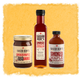 Gift Set of Three bottles of Sugar Bob's smoked maple products on a textured yellow background on a yellow background
