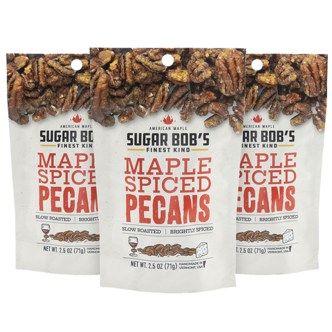 Three packages of Sugar Bob's Maple Spiced Pecans on a white background.