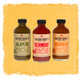 Three bottles of Sugar Bob's Maple Sriracha on a textured yellow background