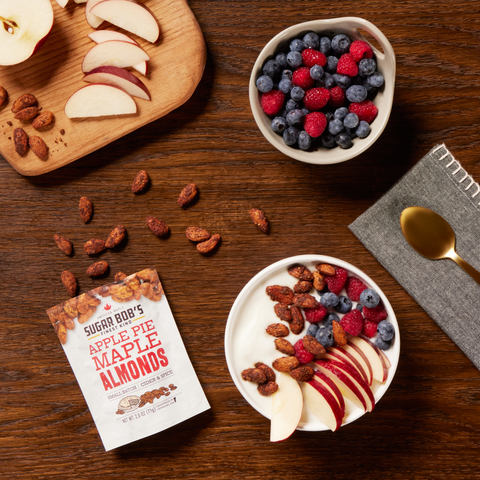 Yogurt bowl with fruits and almonds on a wooden table