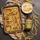Tray of fries with a bowl of sauce and bottle of jalapeno maple sriracha on a towel.